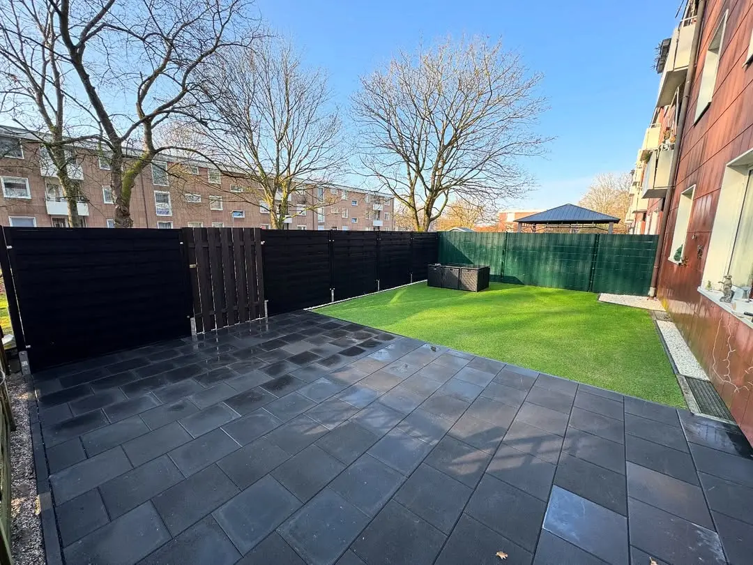 Fertig gestellte Terrasse mit Rollrasen - Perfekte Kombination aus Steinflächen und Grün