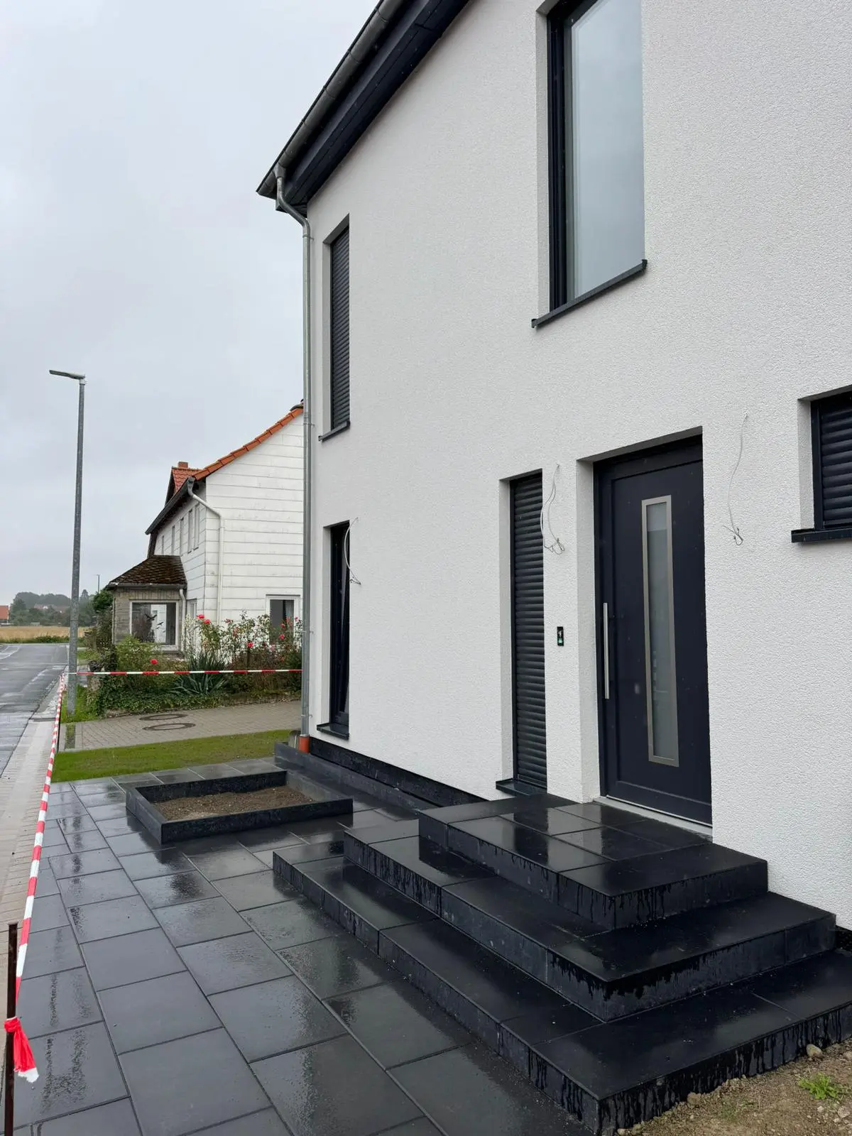 Elegant gepflasterte Einfahrt mit dunklen Natursteinstufen